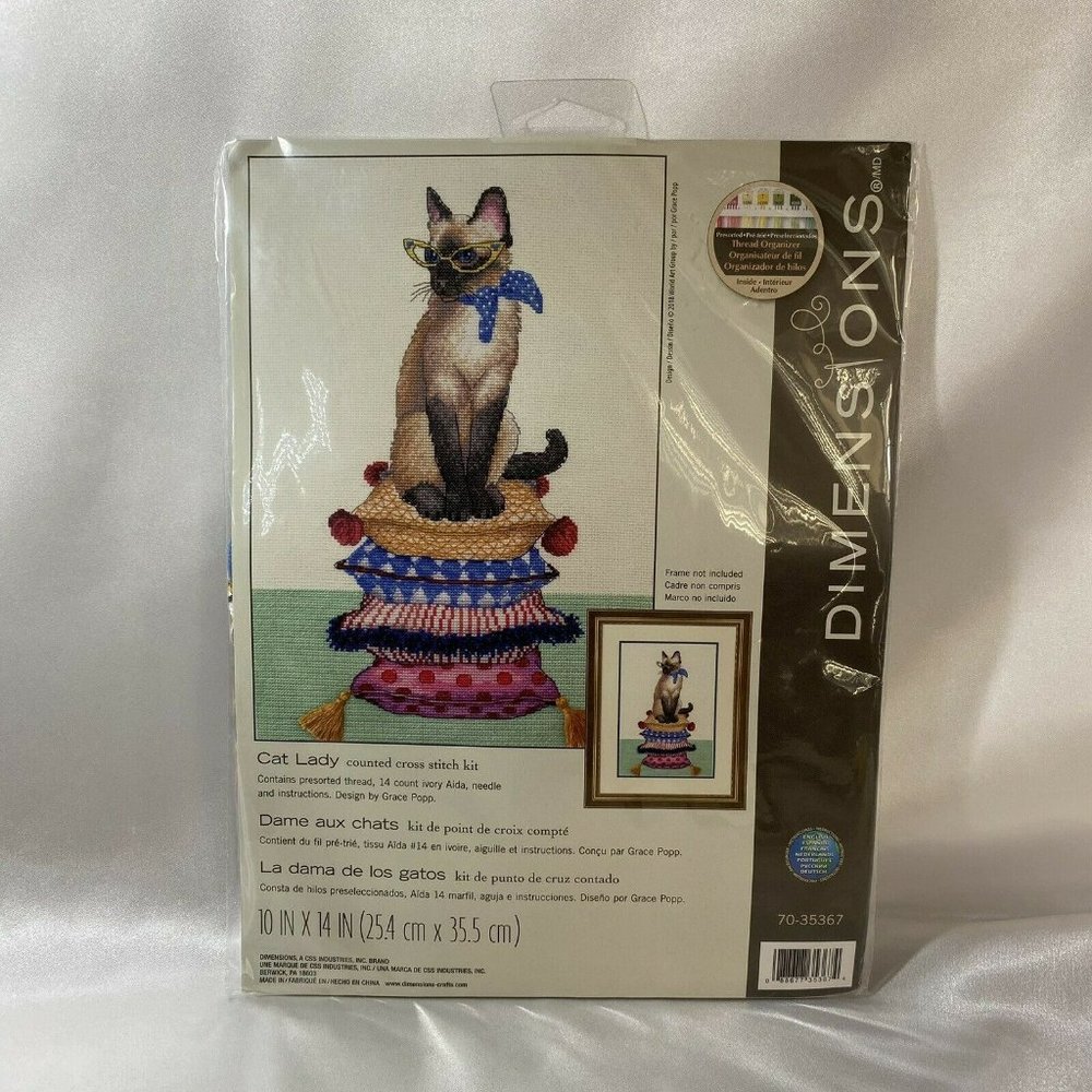 Siamese Cat Wearing Glasses on Pillow Stack Cross